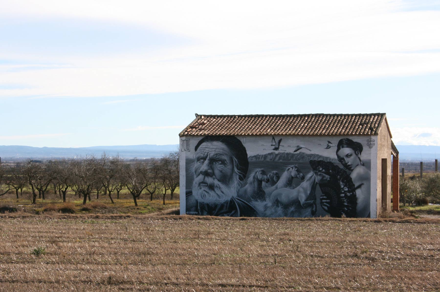 Foto d'una casa amb un dibuix a la paret situat al poble de Penelles. La foto es pot veure a la pàgina 'allotjament privat per a grups'.